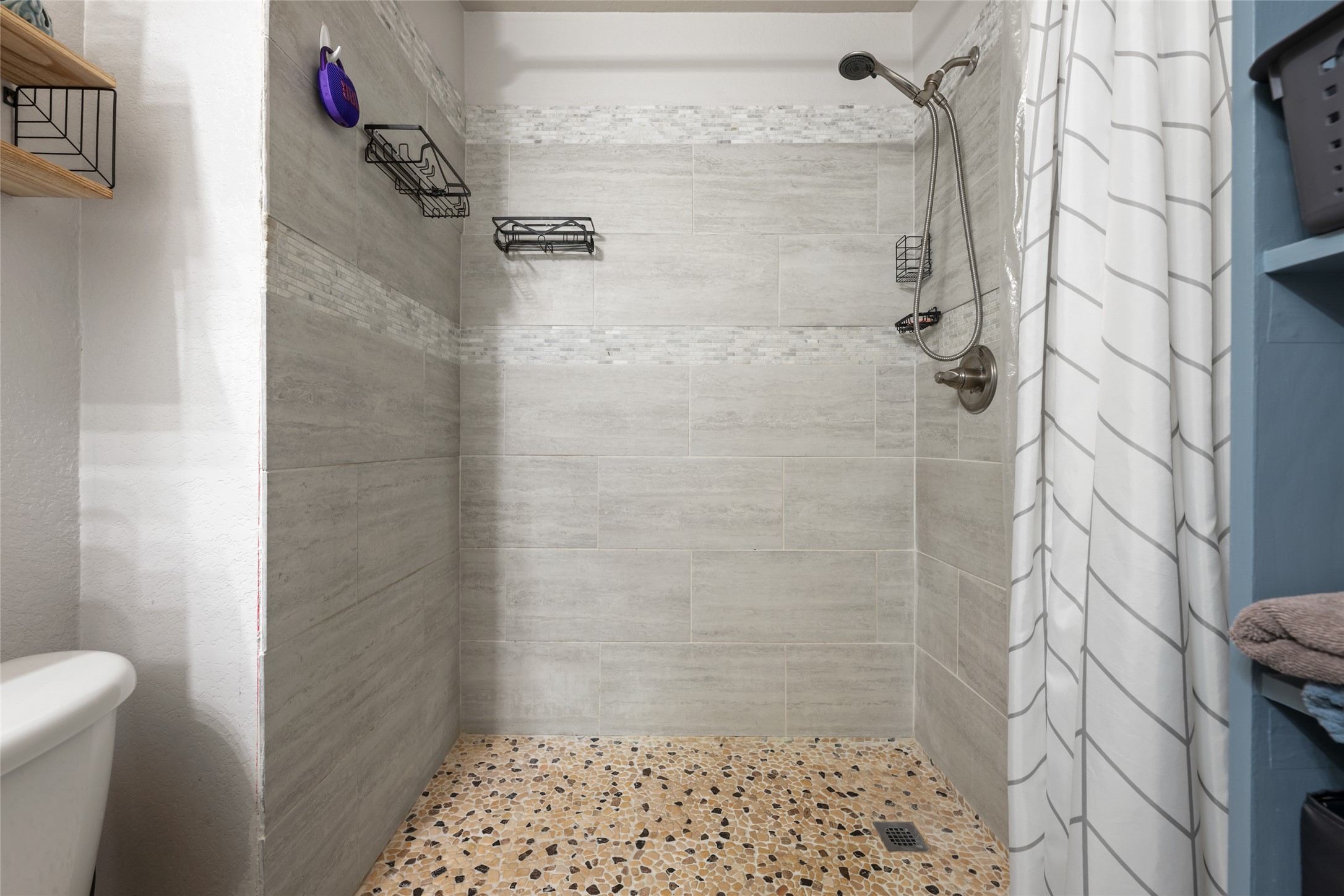 144 Calcite Lane Jarrell, TX 76537 - Photo 23 of 38 A well-appointed shower with modern tile work and a distinctive pebble-stone floor.