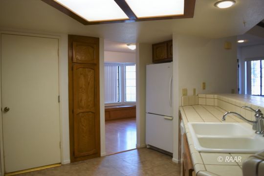 217 Kennedy Court Ridgecrest, CA 93555 - Photo 8 of 28 a kitchen with a refrigerator and a sink