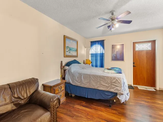 a bedroom with a bed couch and chandelier