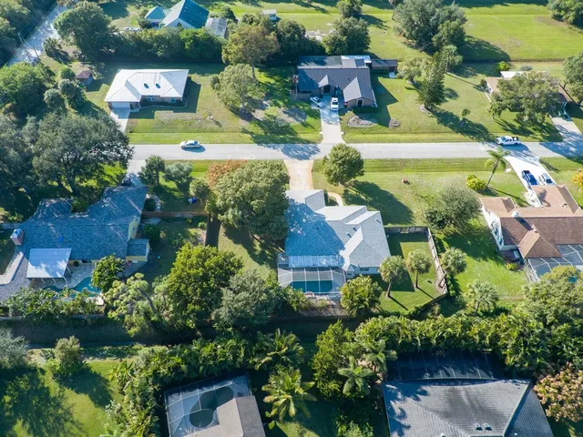 an aerial view of a house with a yard swimming pool and outdoor seating