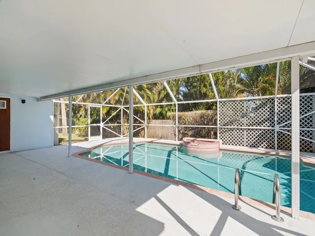 a view of a room with a large window and wooden floor