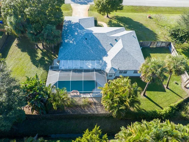 an aerial view of a house with a garden and lake view