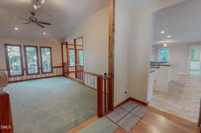 a view of a kitchen with kitchen island wooden floors and stainless steel appliances