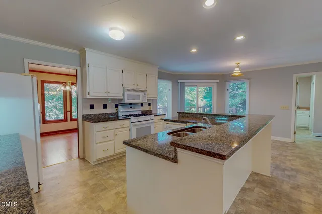 a kitchen with granite countertop a sink a counter top space and stainless steel appliances
