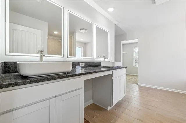 a bathroom with a granite countertop sink and a mirror