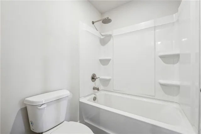 a white toilet and tub sitting next to a bathroom sink