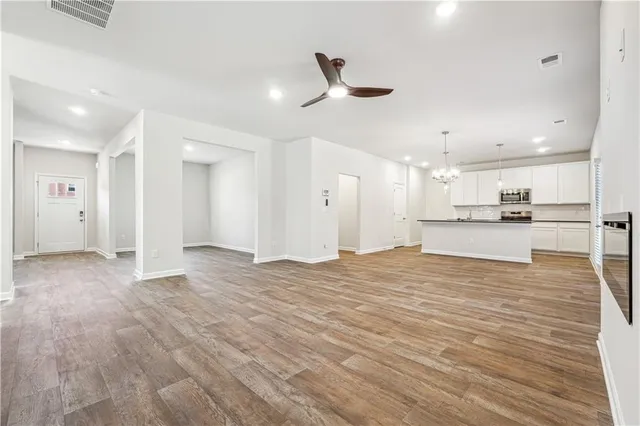 a view of an empty room and kitchen view
