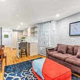 a living room with furniture kitchen view and a large window