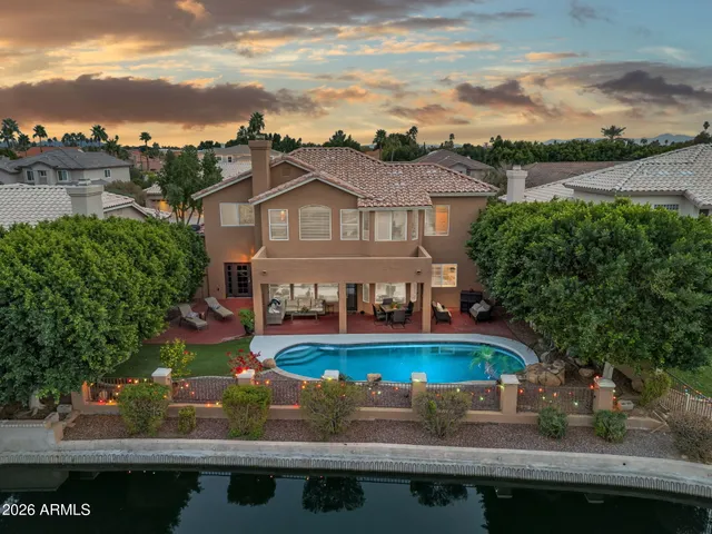 a view of a swimming pool with lawn chairs under an umbrella