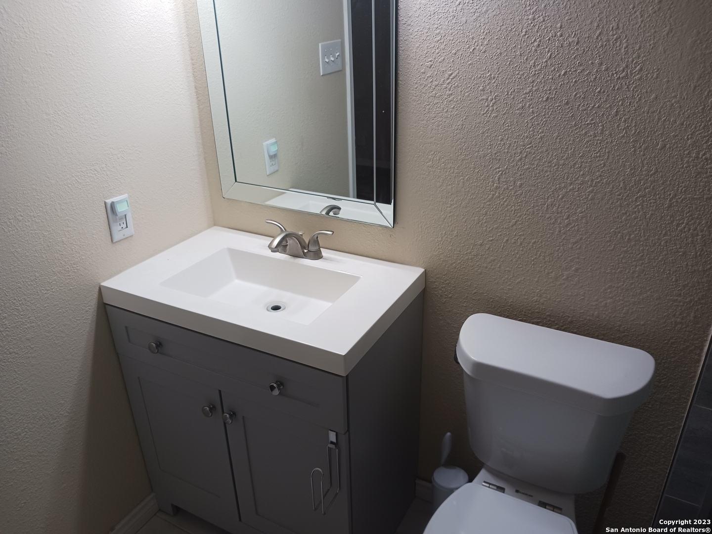 11725 Spring Ridge Drive San Antonio, TX 78249 - Photo 15 of 18 a bathroom with a toilet sink and mirror