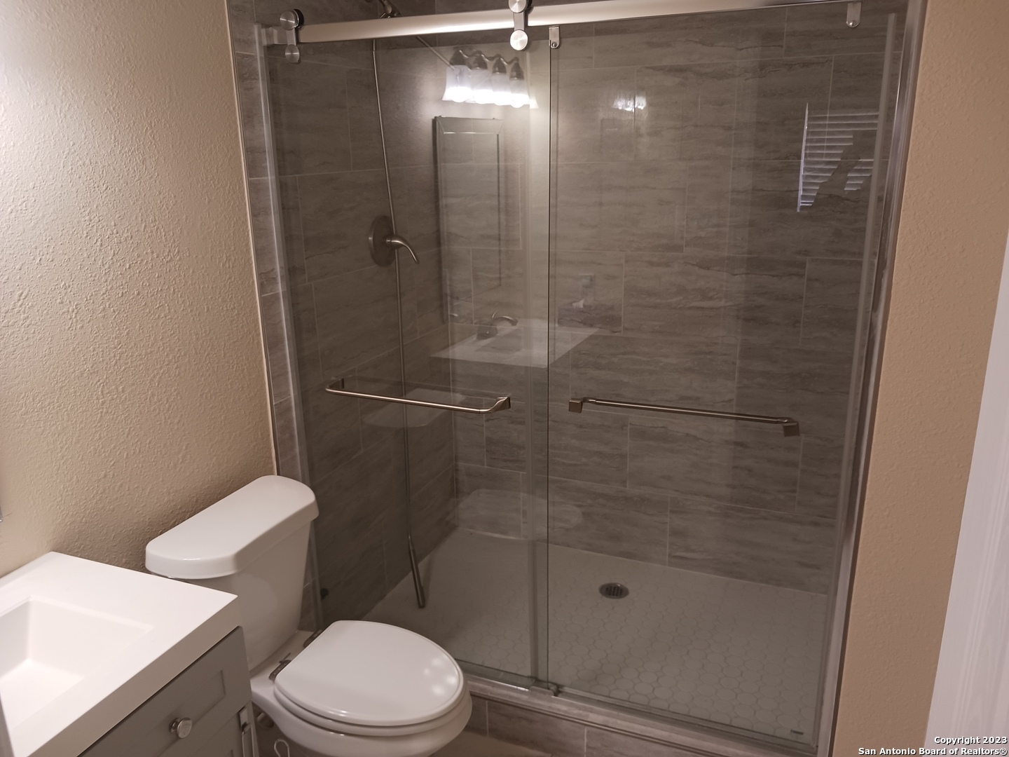 11725 Spring Ridge Drive San Antonio, TX 78249 - Photo 16 of 18 a bathroom with a shower a toilet and sink