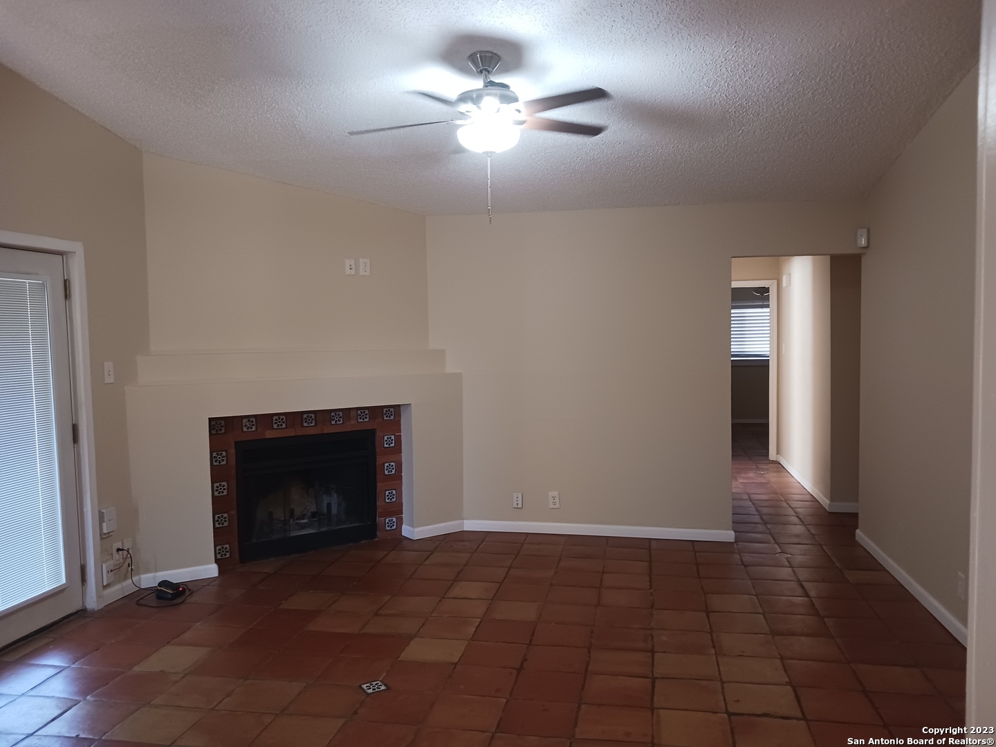 11725 Spring Ridge Drive San Antonio, TX 78249 - Photo 3 of 18 a view of an empty room with chandelier fan and fire place
