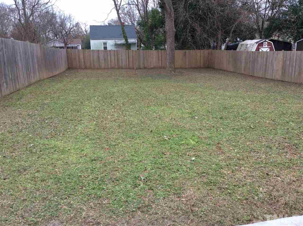 1309 Lake Wheeler Road Raleigh, NC 27603 - Photo 14 of 17 a view of a backyard with tree and wooden fence