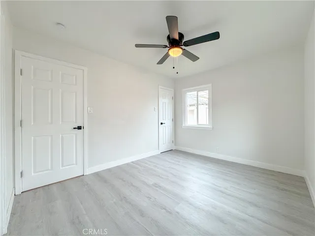 a view of a big room with wooden floor and windows
