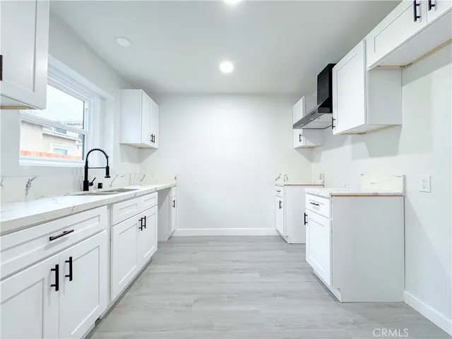 a kitchen with cabinets oven and a sink