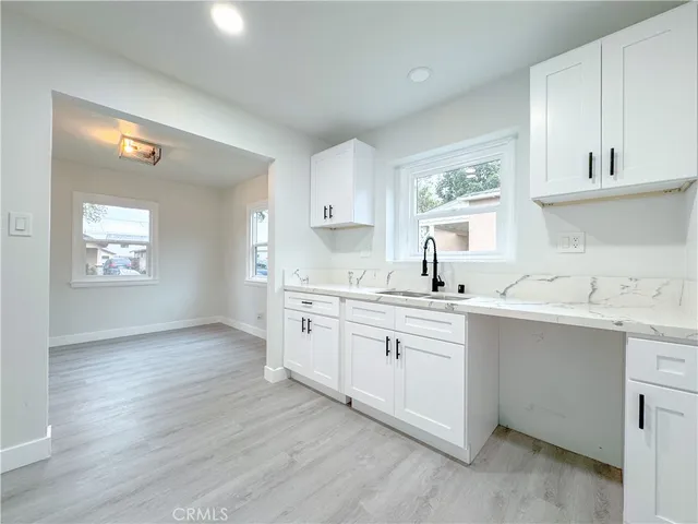 a kitchen with granite countertop a sink stove and cabinets