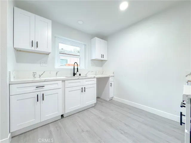 a kitchen with cabinets appliances a sink and a window