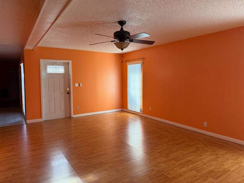 7101 Northwest 68th Street Tamarac, FL 33321 - Photo 3 of 12 a view of an empty room with wooden floor