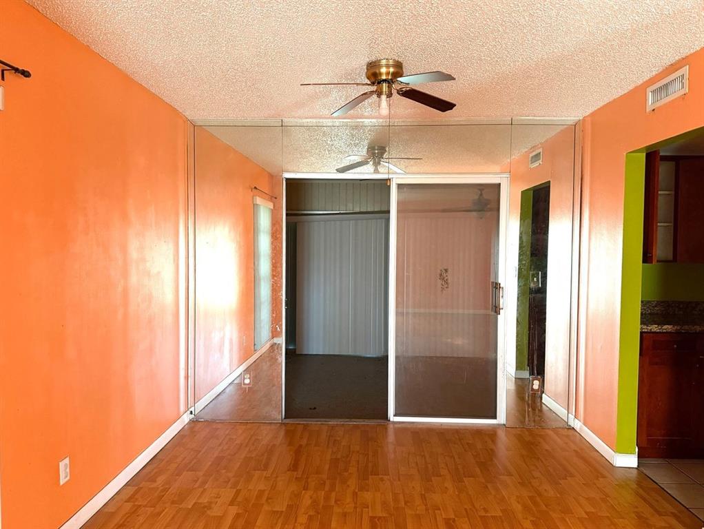 7101 Northwest 68th Street Tamarac, FL 33321 - Photo 4 of 12 a view of hallway with wooden floor and chandelier