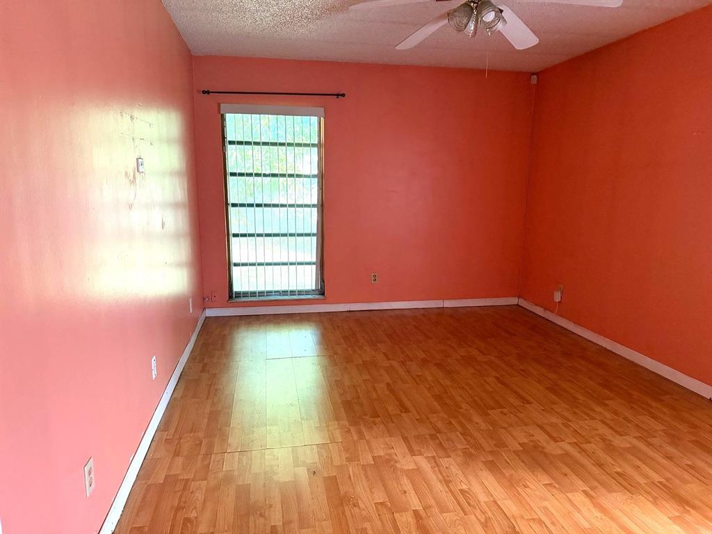 7101 Northwest 68th Street Tamarac, FL 33321 - Photo 6 of 12 an empty room with wooden floor and windows