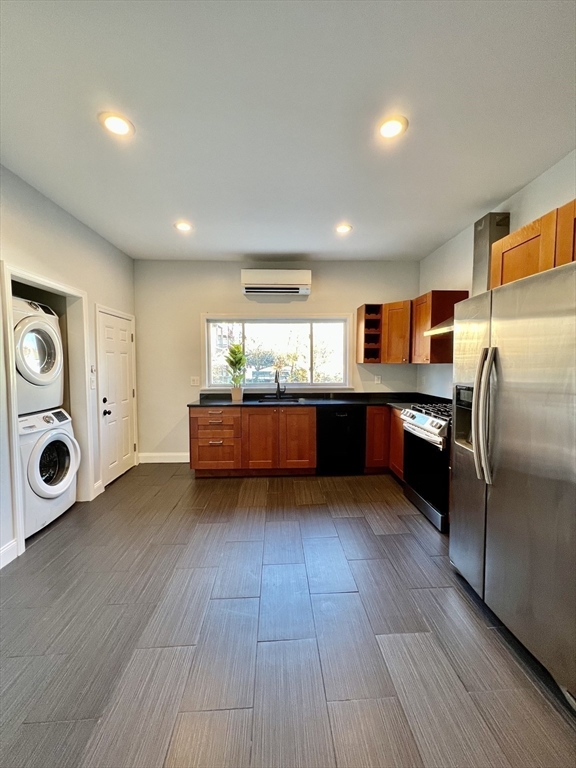 a kitchen with stainless steel appliances granite countertop a refrigerator a stove and a wooden floors