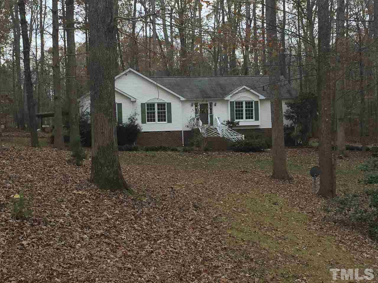 a front view of a house with a yard and tree s