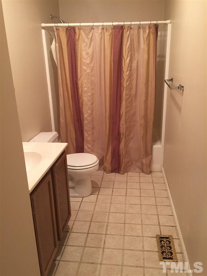 241 Shannon Road Timberlake, NC 27583 - Photo 11 of 17 a bathroom with a sink a toilet a mirror and shower curtain
