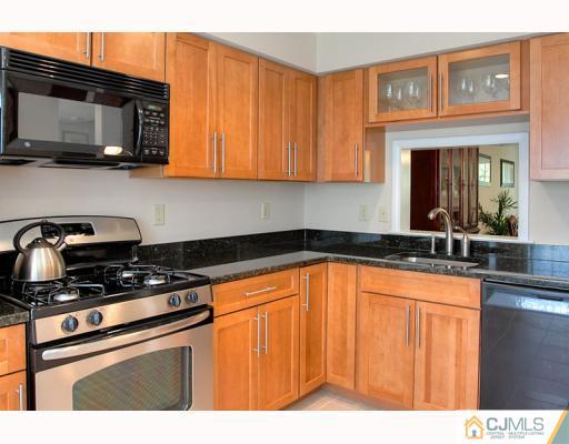 3406 Springbrook Drive Edison, NJ 08820 - Photo 3 of 10 a kitchen with stainless steel appliances granite countertop a sink stove and microwave