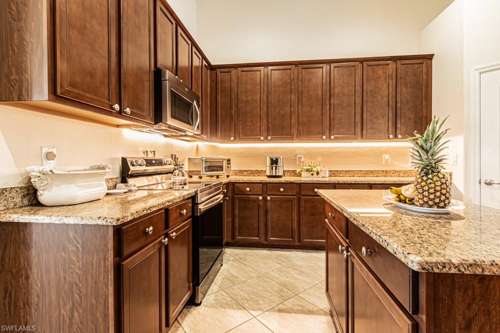 27151 Mora Road Bonita Springs, FL 34135 - Photo 11 of 50 a kitchen with stainless steel appliances granite countertop a sink stove and cabinets