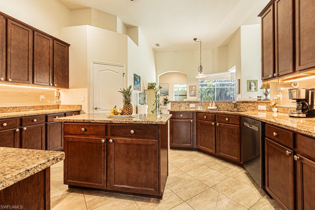 27151 Mora Road Bonita Springs, FL 34135 - Photo 12 of 50 a kitchen with stainless steel appliances granite countertop wooden cabinets a stove top oven and a sink