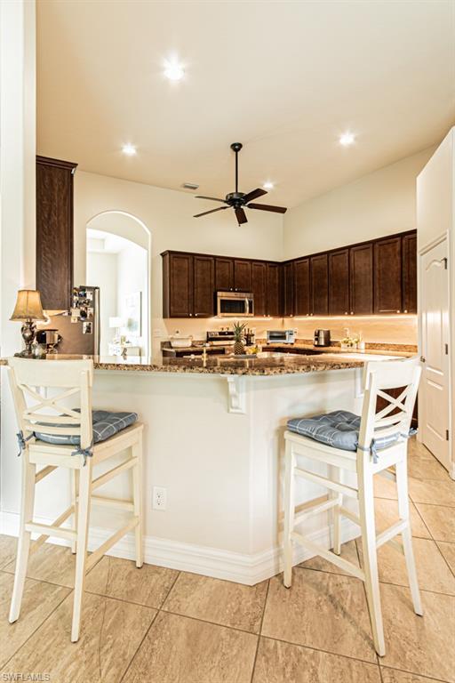 27151 Mora Road Bonita Springs, FL 34135 - Photo 14 of 50 a kitchen with kitchen island granite countertop a counter top space appliances and cabinets
