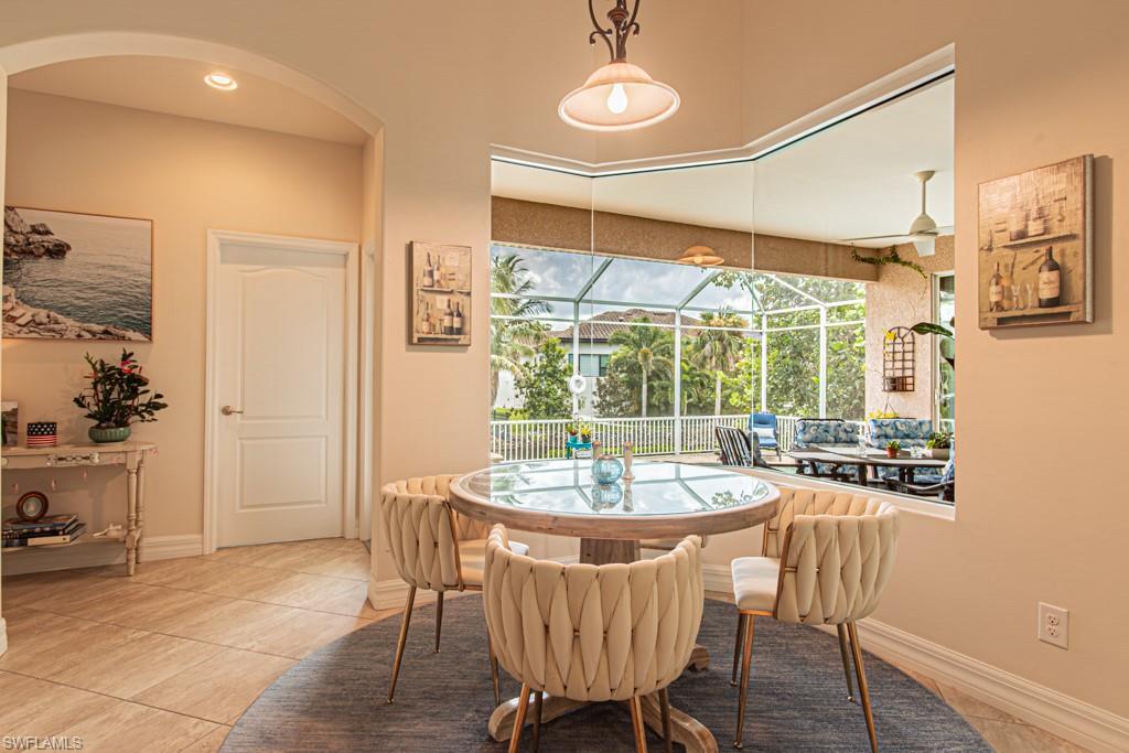 27151 Mora Road Bonita Springs, FL 34135 - Photo 18 of 50 a dining room with furniture a chandelier and wooden floor
