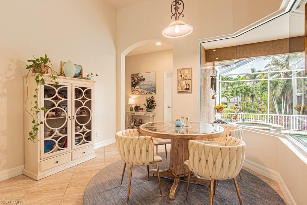 27151 Mora Road Bonita Springs, FL 34135 - Photo 19 of 50 a dining room with furniture a chandelier and wooden floor