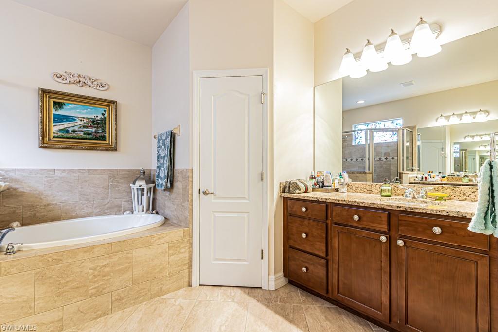 27151 Mora Road Bonita Springs, FL 34135 - Photo 25 of 50 a bathroom with a tub a double vanity sink and a mirror