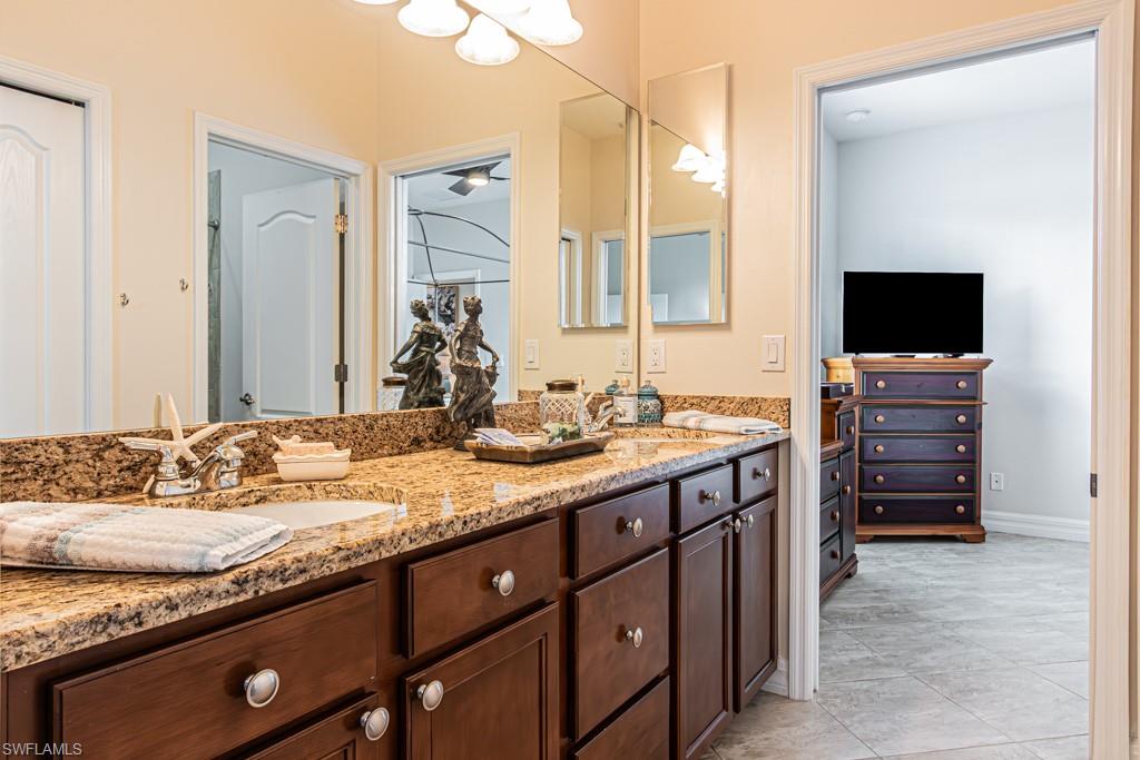 27151 Mora Road Bonita Springs, FL 34135 - Photo 30 of 50 a spacious bathroom with a granite countertop sink and a mirror