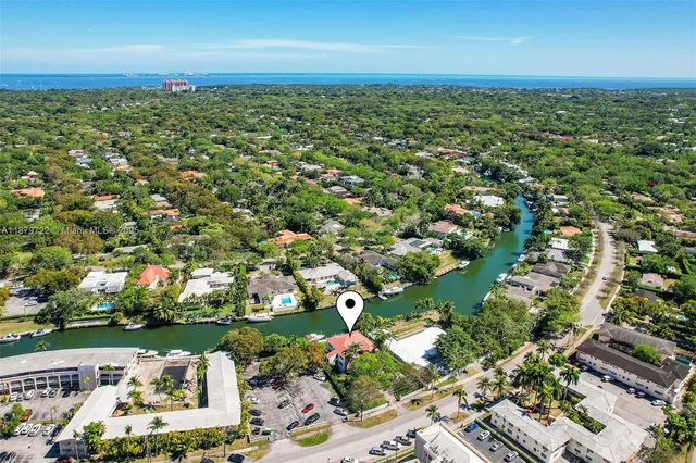 an aerial view of residential houses with outdoor space and trees