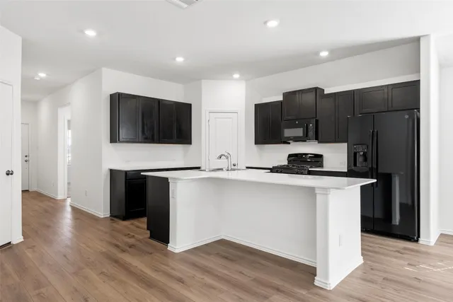 a kitchen with stainless steel appliances granite countertop a sink a stove and a refrigerator