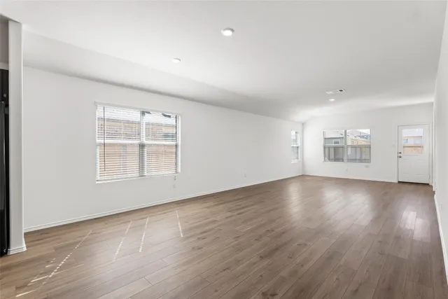 a view of kitchen with stainless steel appliances a sink dishwasher a refrigerator and a stove with wooden floor