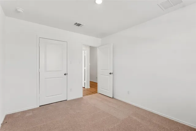 a view of a big room with wooden floor and a window