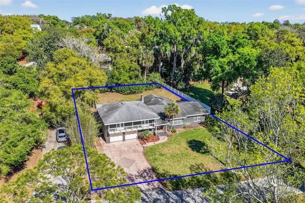 an aerial view of a backyard with swimming pool and outdoor seating