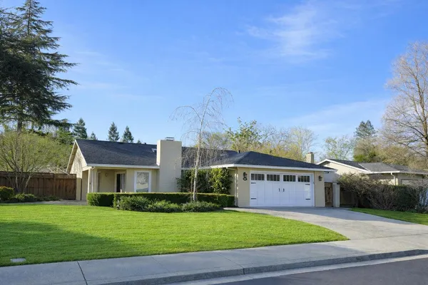 a front view of a house with a garden and yard