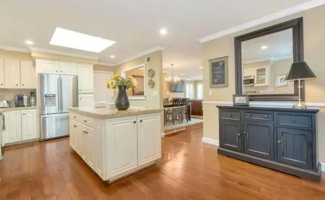 a large kitchen with kitchen island white cabinets and stainless steel appliances