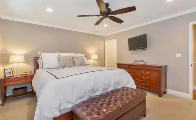 a bedroom with a bed and a tv on dresser