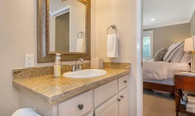 a bathroom with a granite countertop sink and a mirror