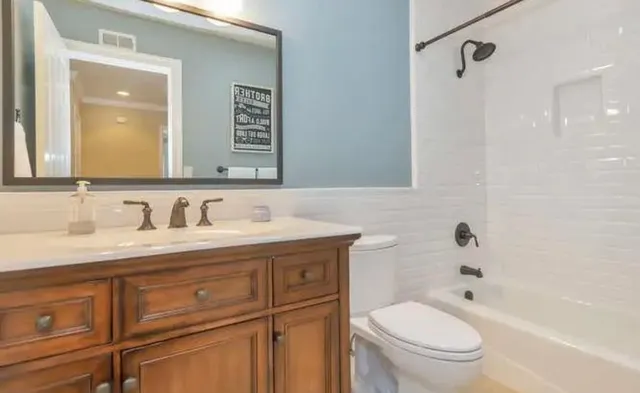a bathroom with a granite countertop sink toilet and shower