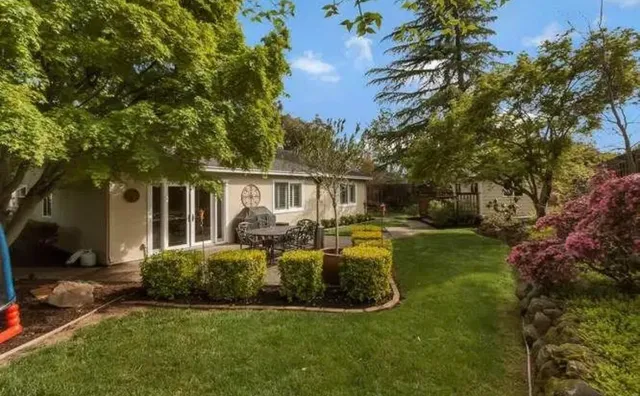 a view of a house with backyard and sitting area