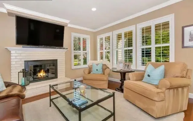 a living room with furniture fireplace and flat screen tv