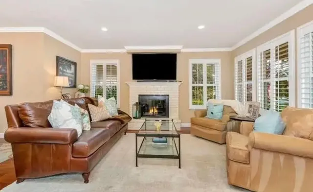 a living room with furniture a flat screen tv and a fireplace