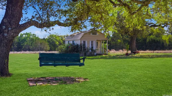a view of a house with backyard and a tree