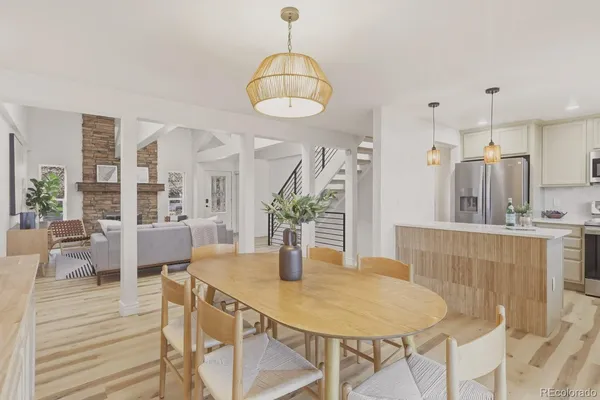 a kitchen with stainless steel appliances kitchen island granite countertop a table chairs and white cabinets
